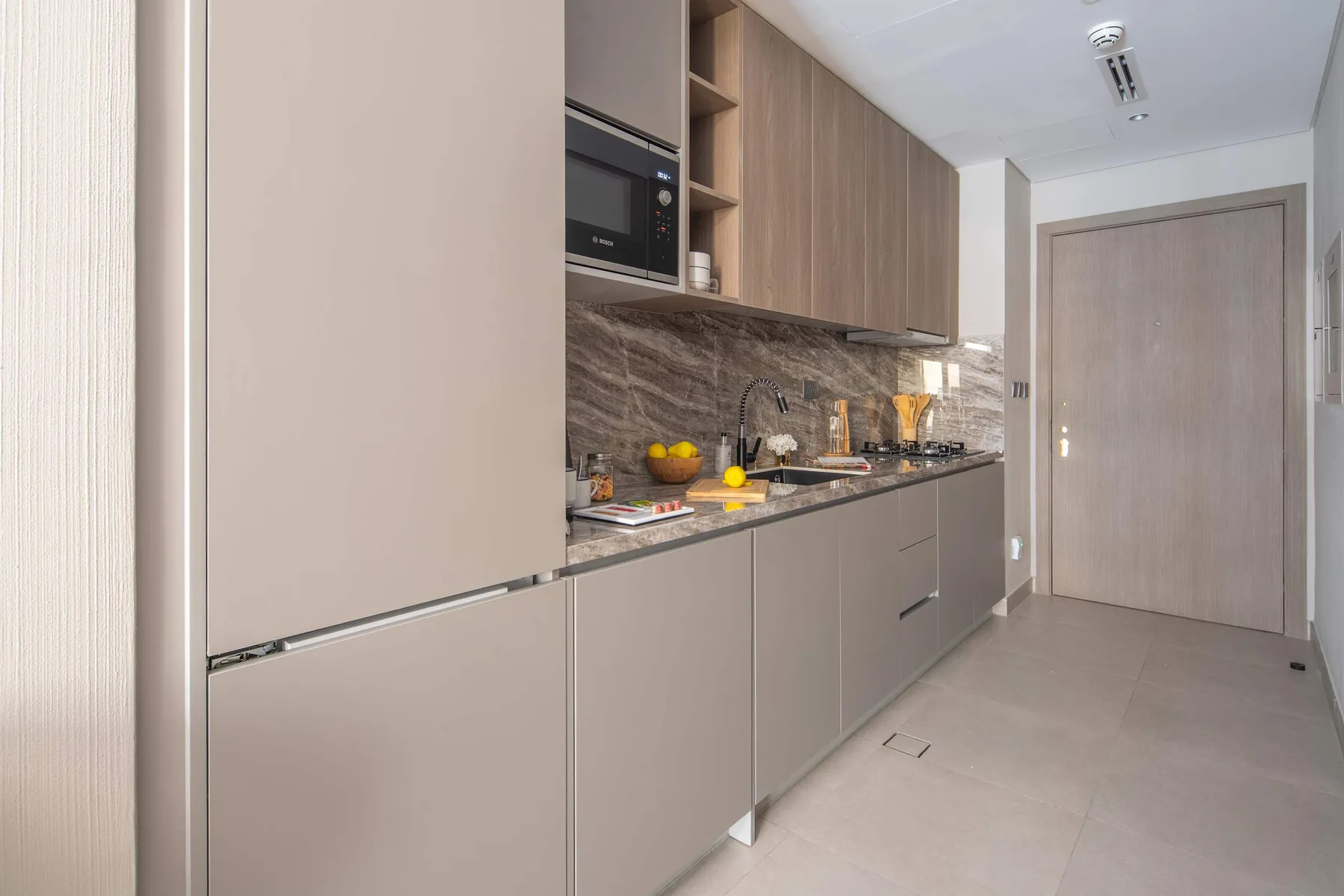A modern kitchen with a countertop, cabinets, and a microwave.