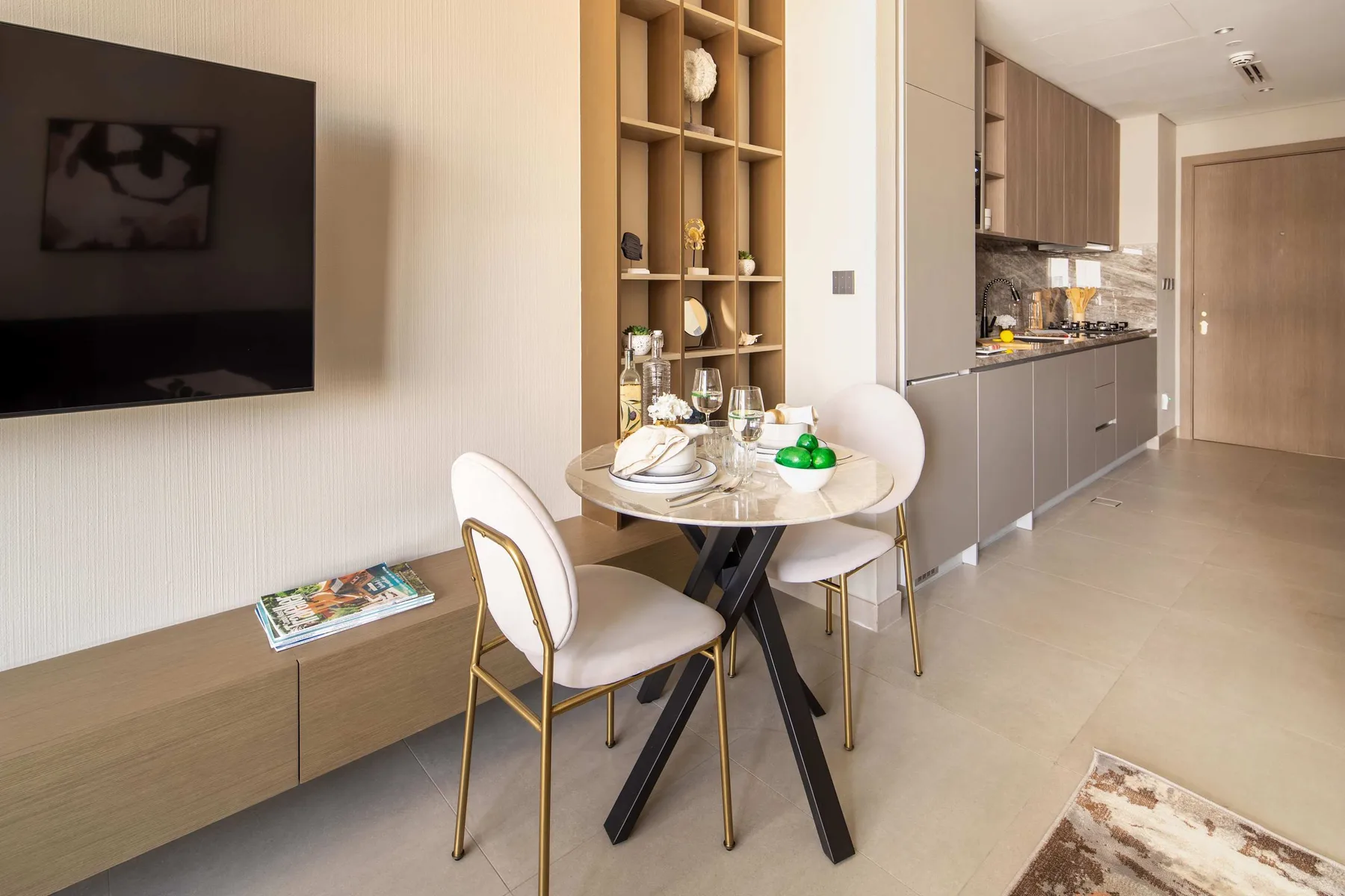 A dining area with a round table beside an open kitchen.