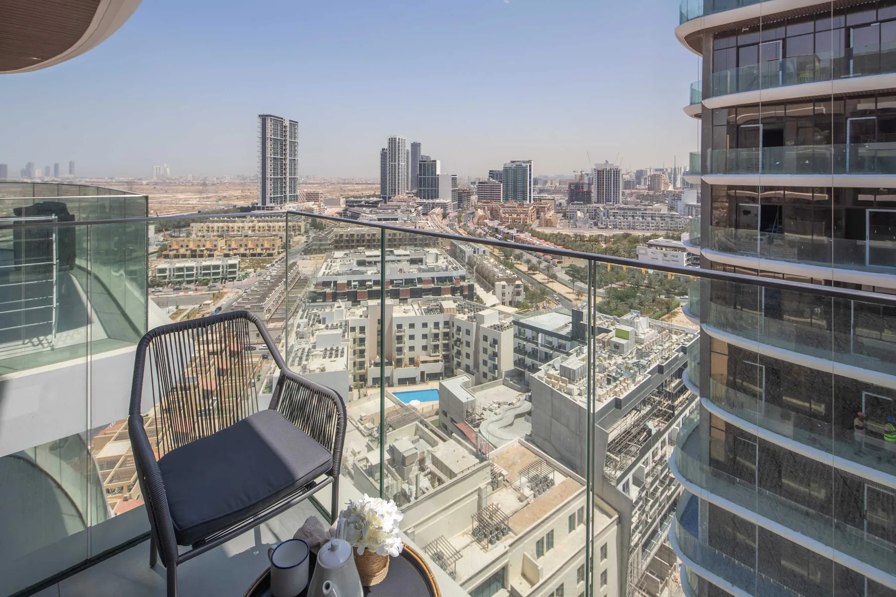 A balcony seating area overlooks a dense city skyline.