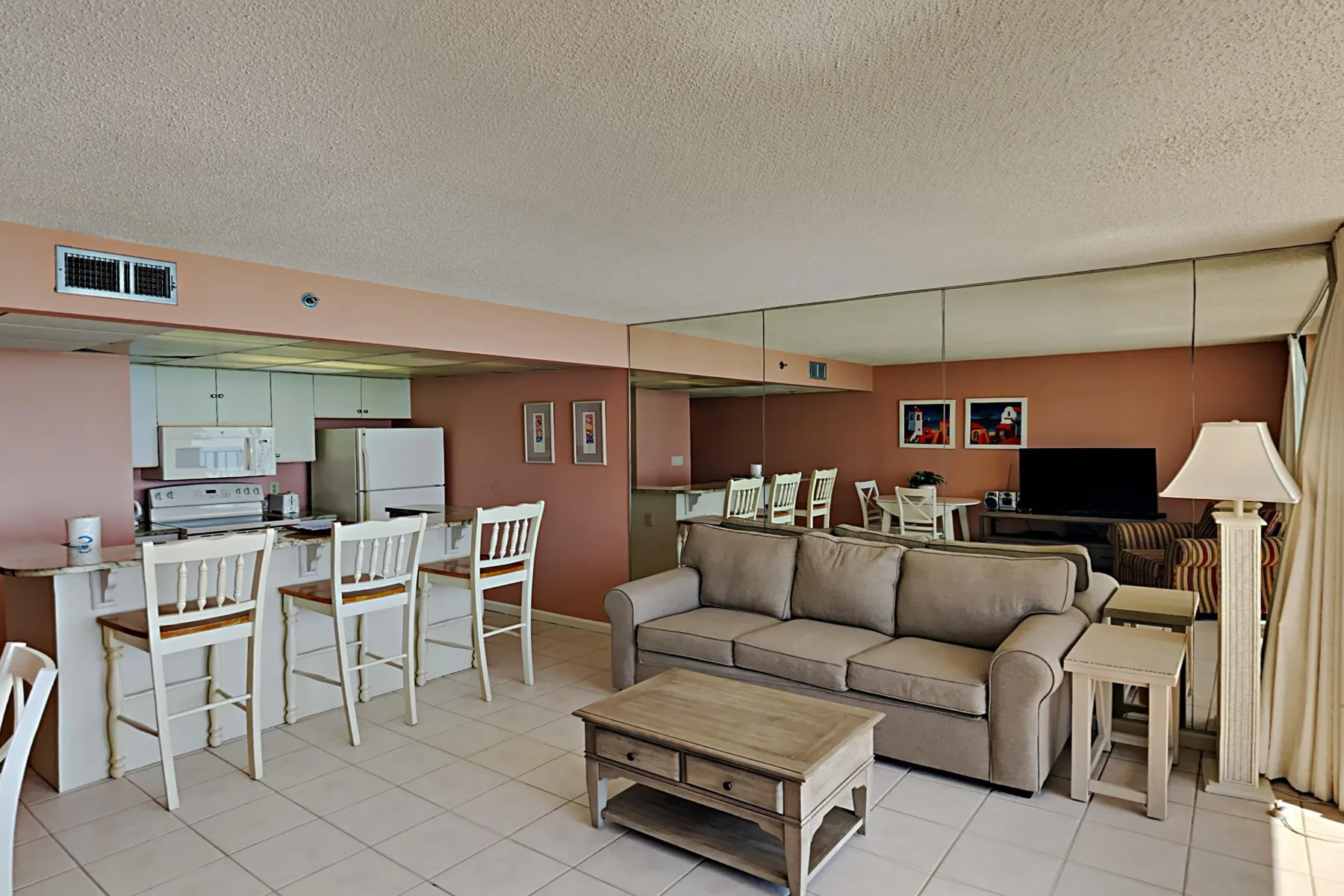 A living room with a sofa, coffee table, and dining area.