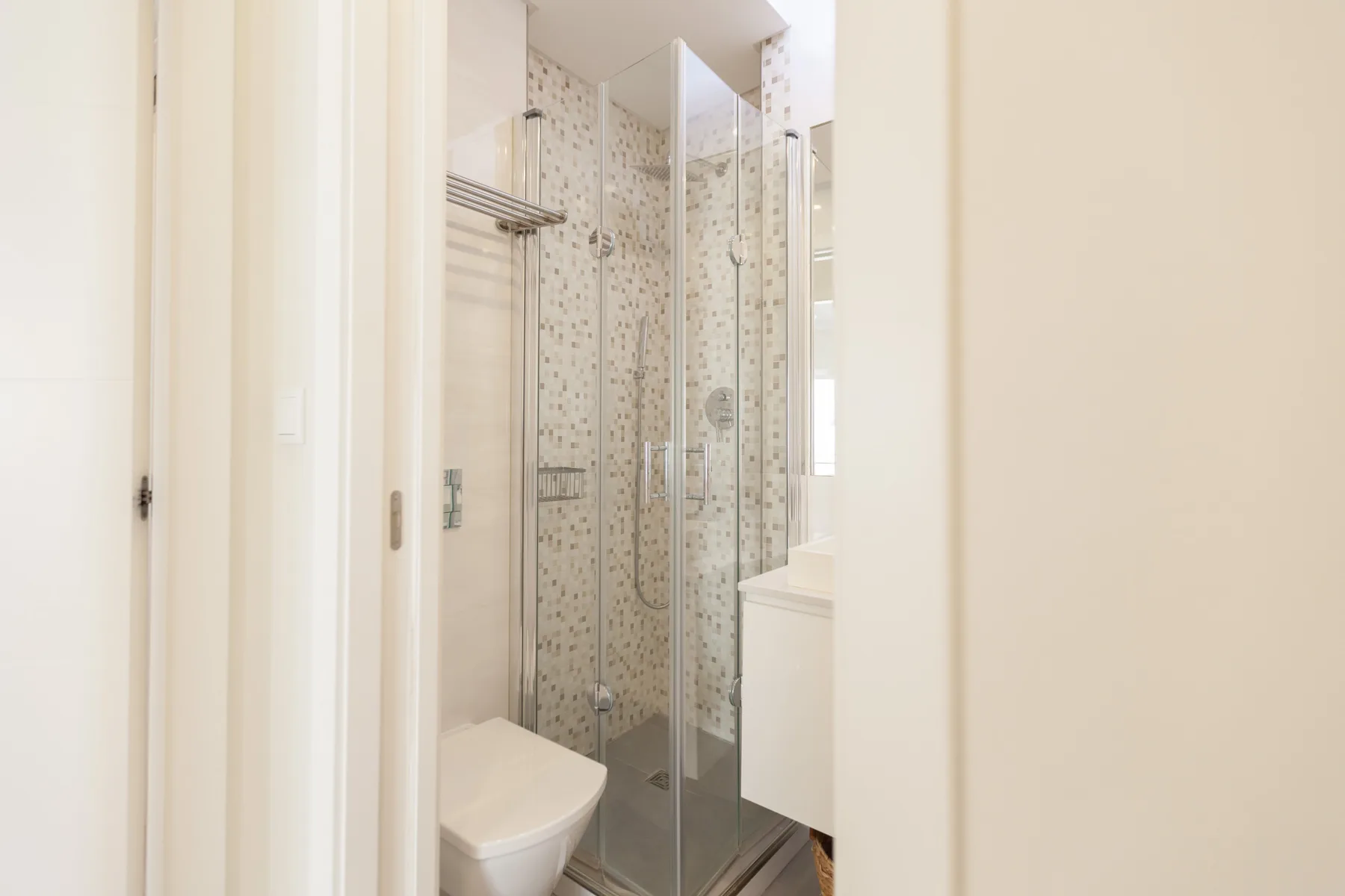 A bathroom with a glass shower and a toilet.