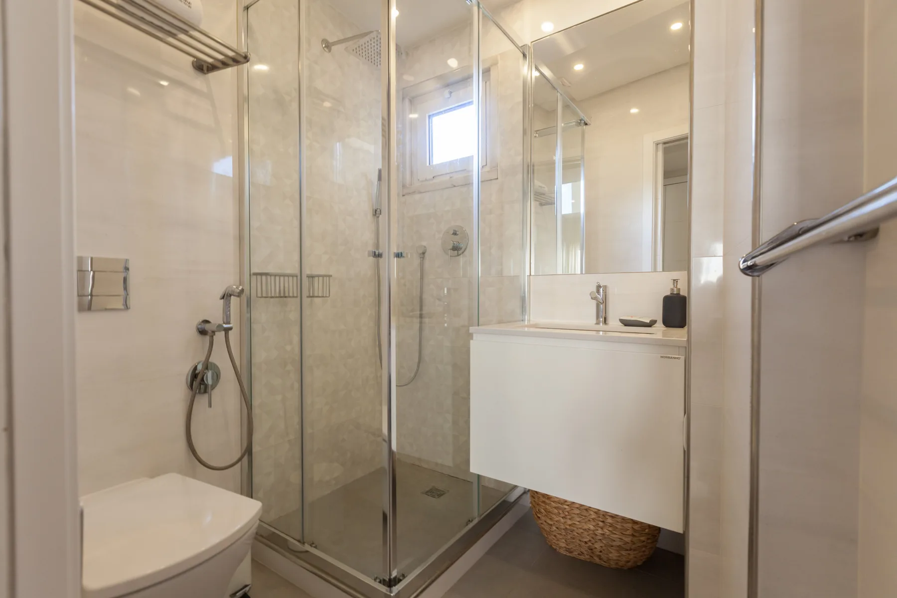 A bathroom with a glass shower and a sink.
