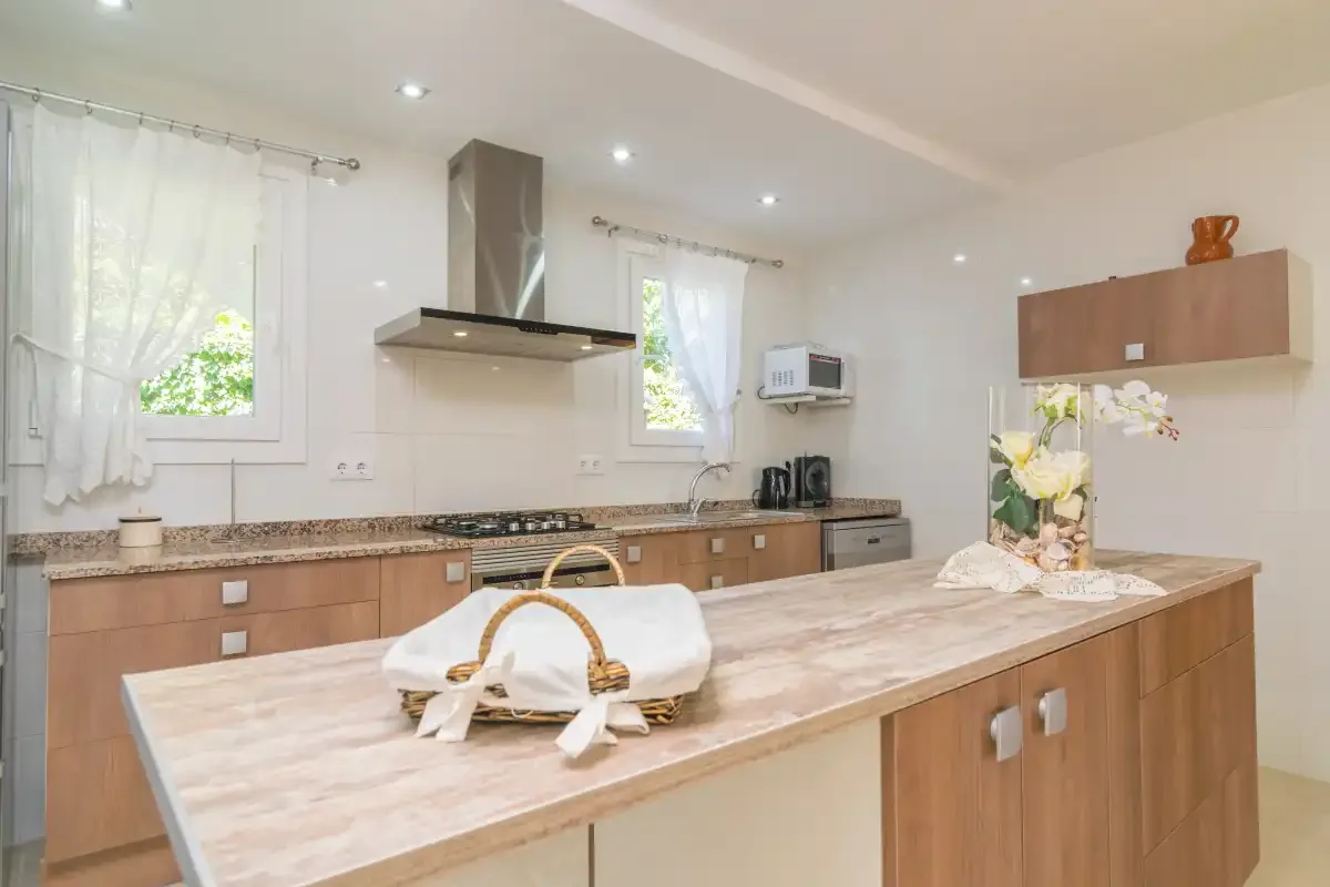 Una cocina luminosa con armarios de madera y una gran isla central.