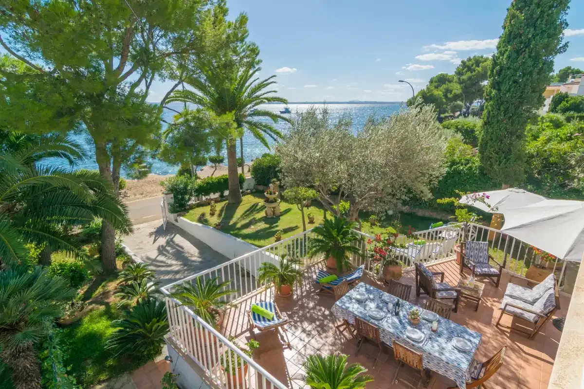 Una terraza ajardinada con asientos al aire libre ofrece vistas al mar.