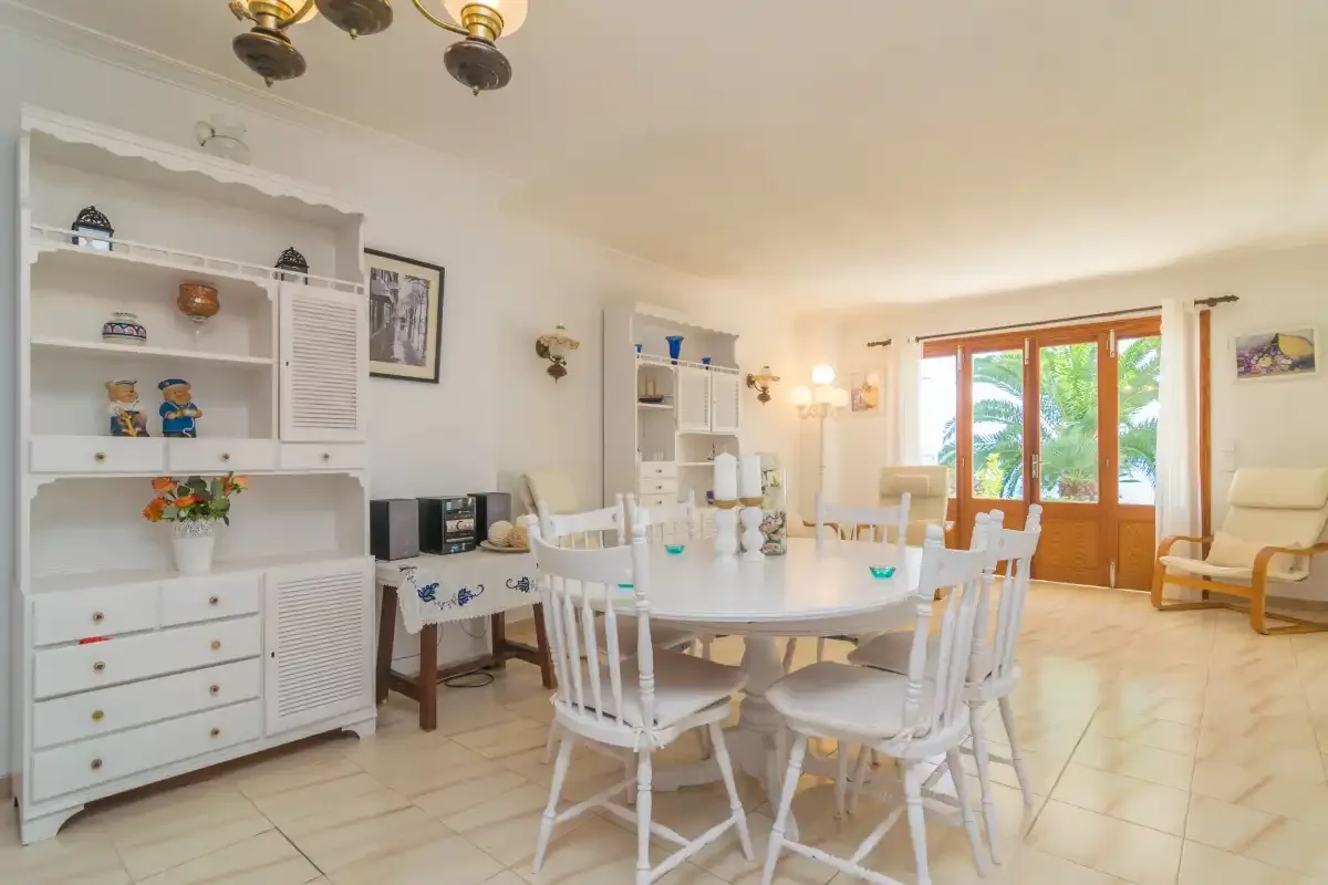 Un comedor luminoso con una mesa grande y puertas que dan a un patio.