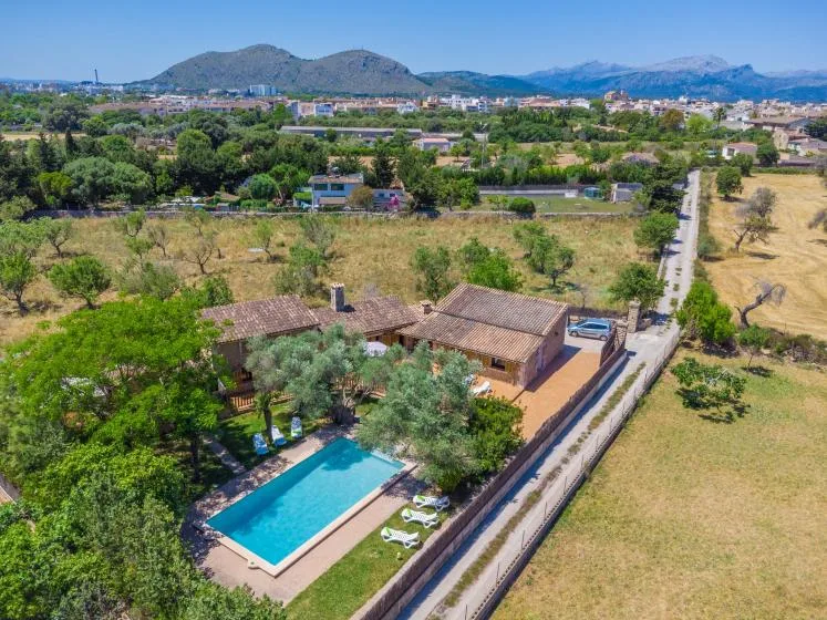 An aerial view of a countryside home with a swimming pool and surrounding fields.