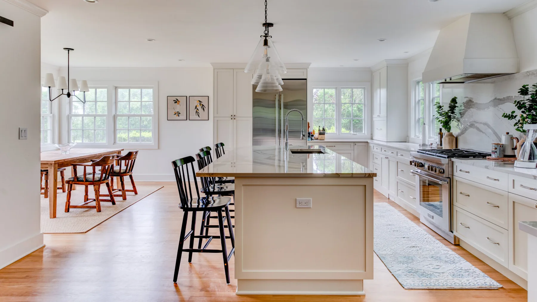 A bright kitchen with a central island and a dining area beside the windows.