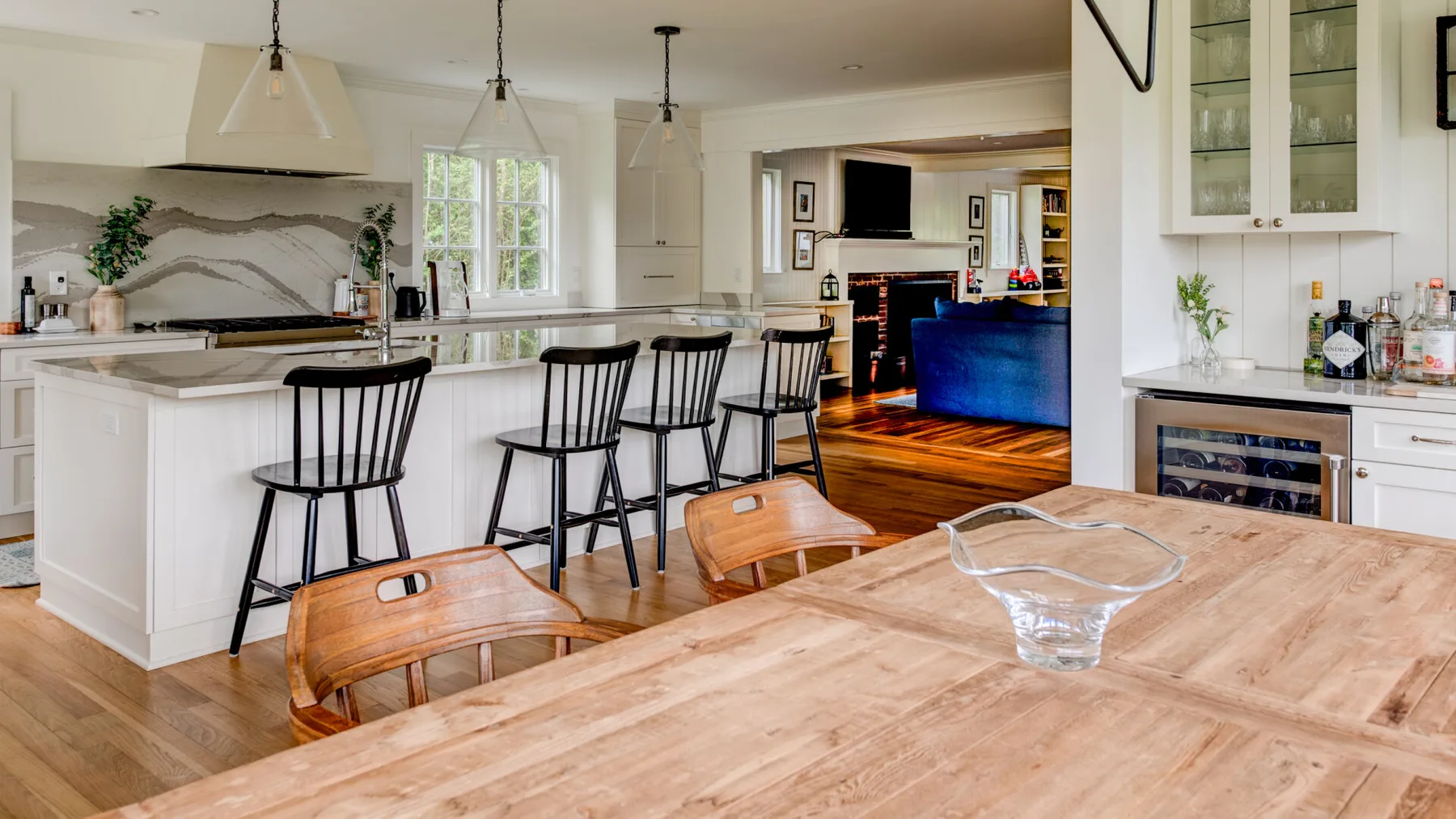 A bright open-plan kitchen and dining area with a large island and wooden table.