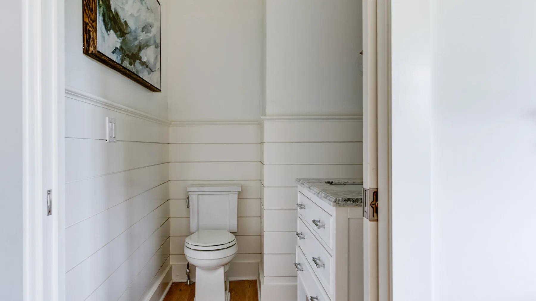 A bright bathroom with a toilet and a vanity.