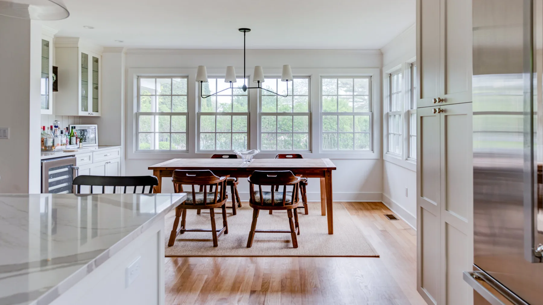 A bright dining area with a wooden table and large windows.