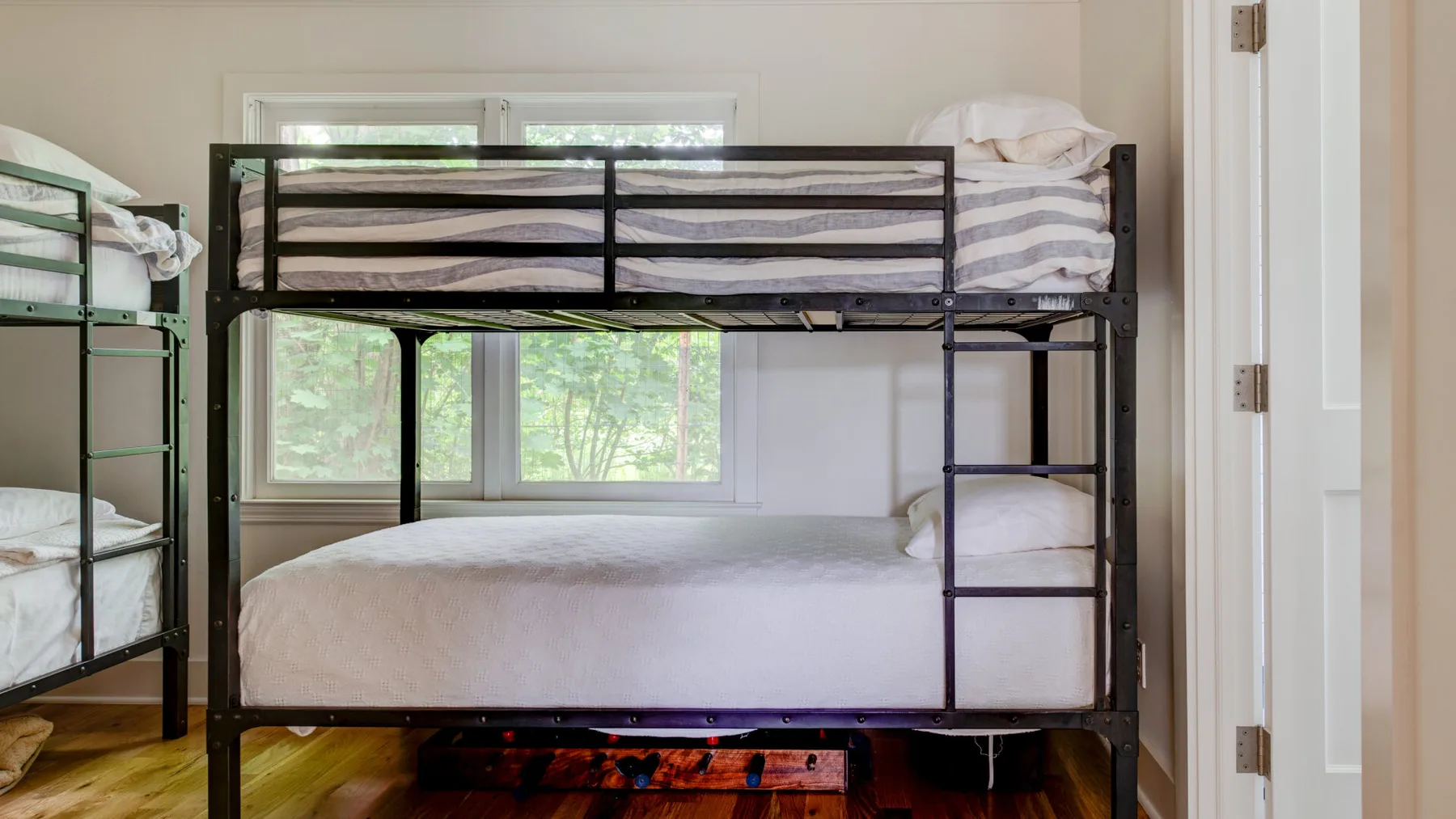 A bedroom with bunk beds, large windows, and a colorful rug.