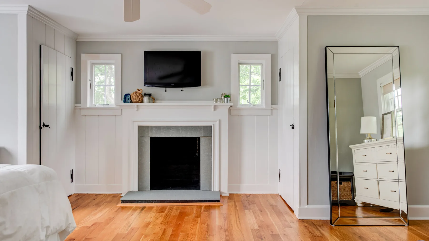 A bright living room with a fireplace and television above the mantel.