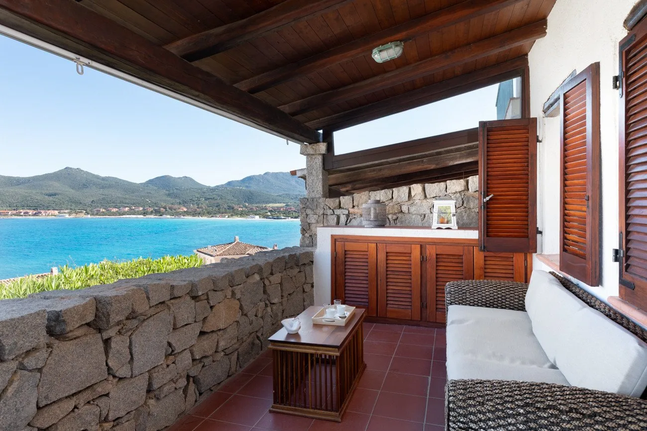 Una terraza cubierta junto al mar, con asientos y vistas a la bahía.