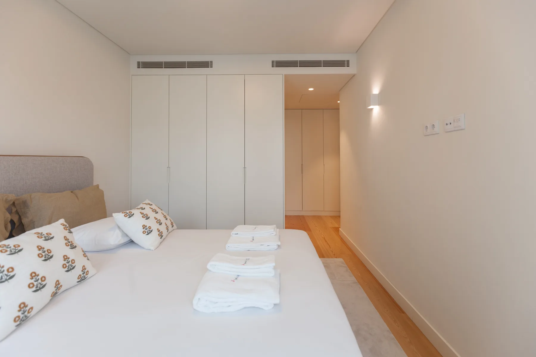 Un dormitorio con una cama bien hecha y toallas.
