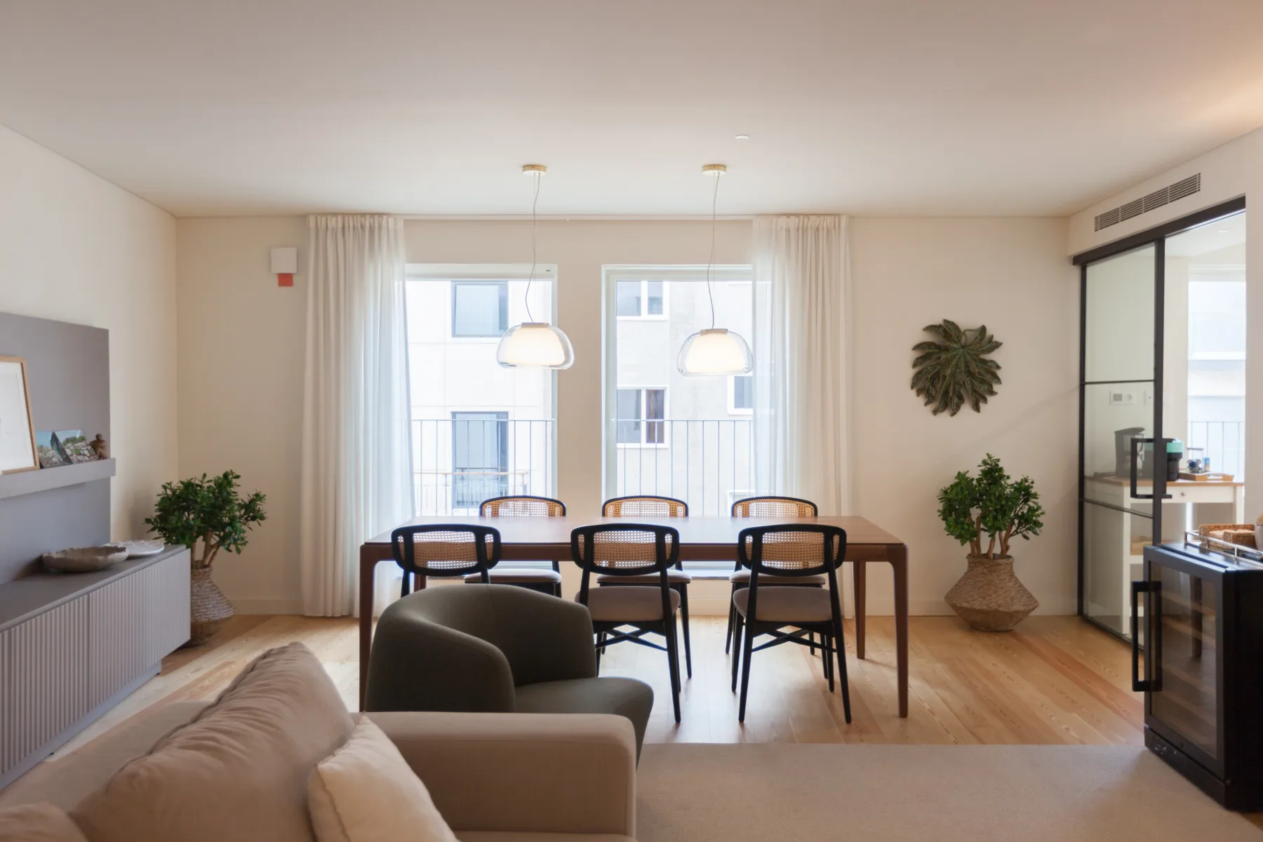 Un comedor luminoso con una mesa larga junto a la sala de estar.