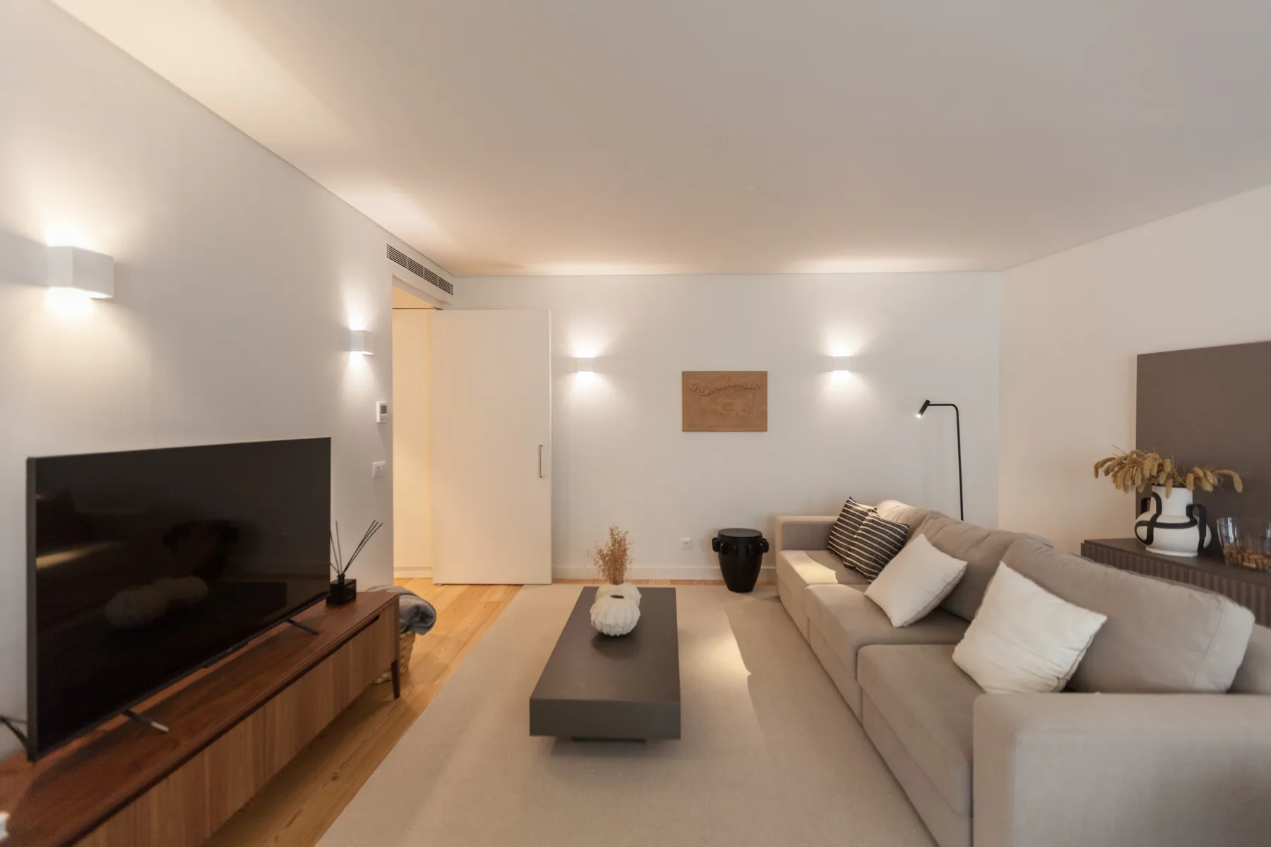 Una sala de estar con sofá, televisor y mesa de centro baja.