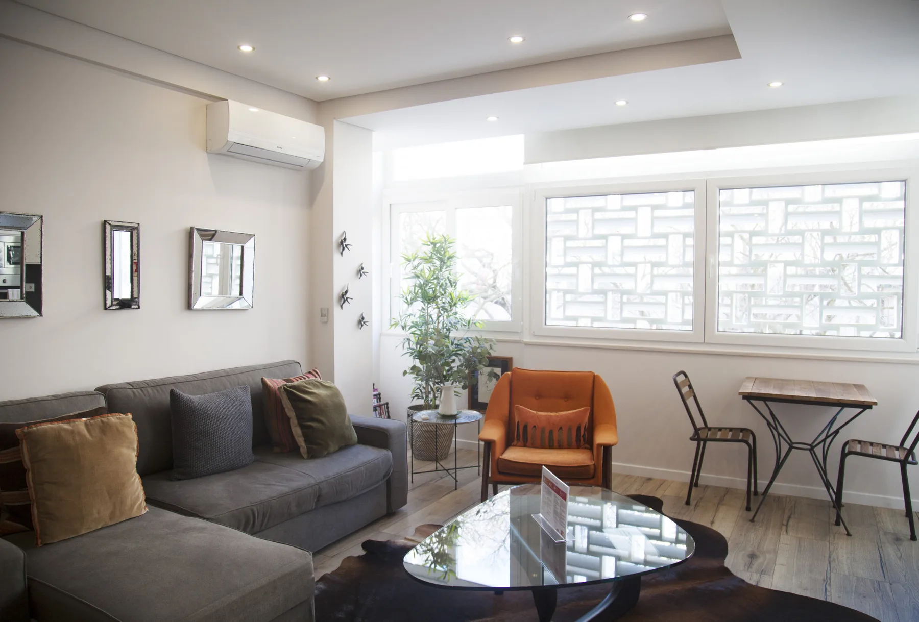 A bright living room with seating beside large windows.