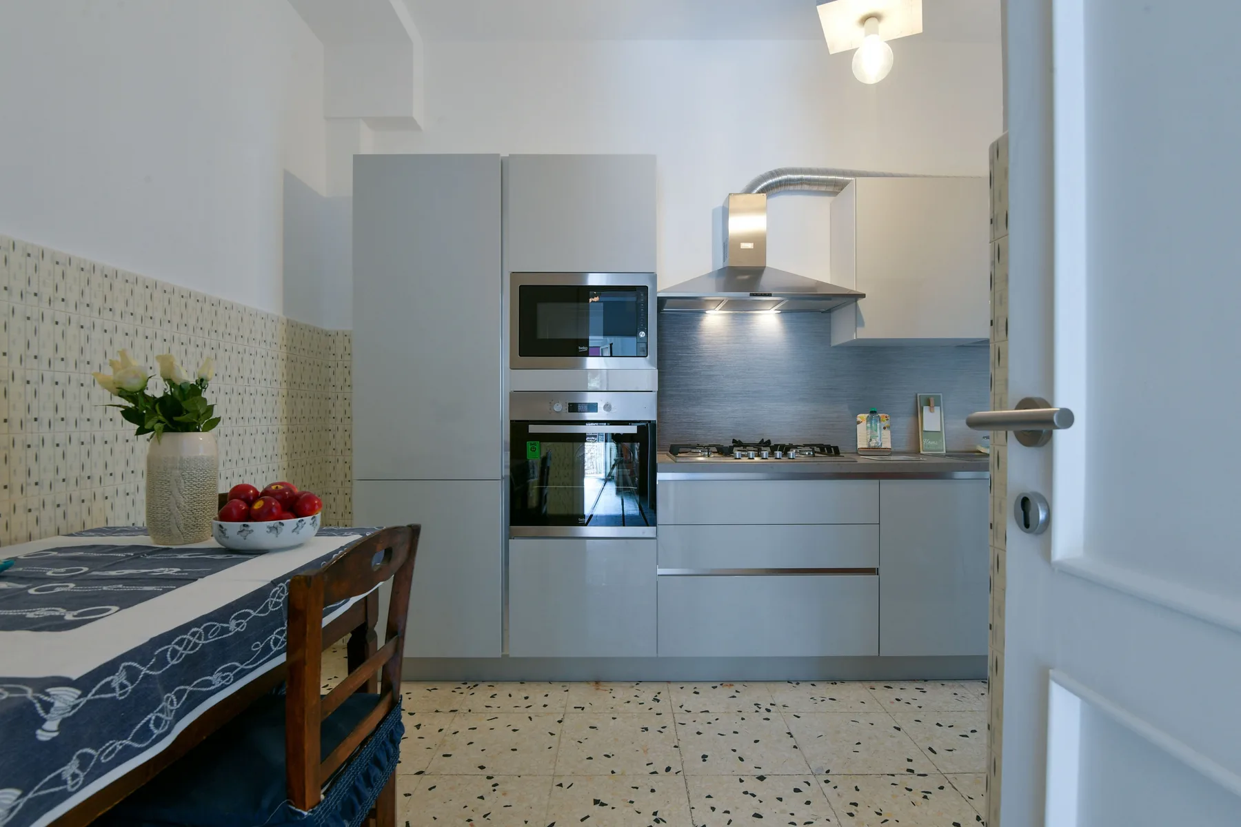 Una cocina moderna con electrodomésticos integrados y una pequeña mesa de comedor.