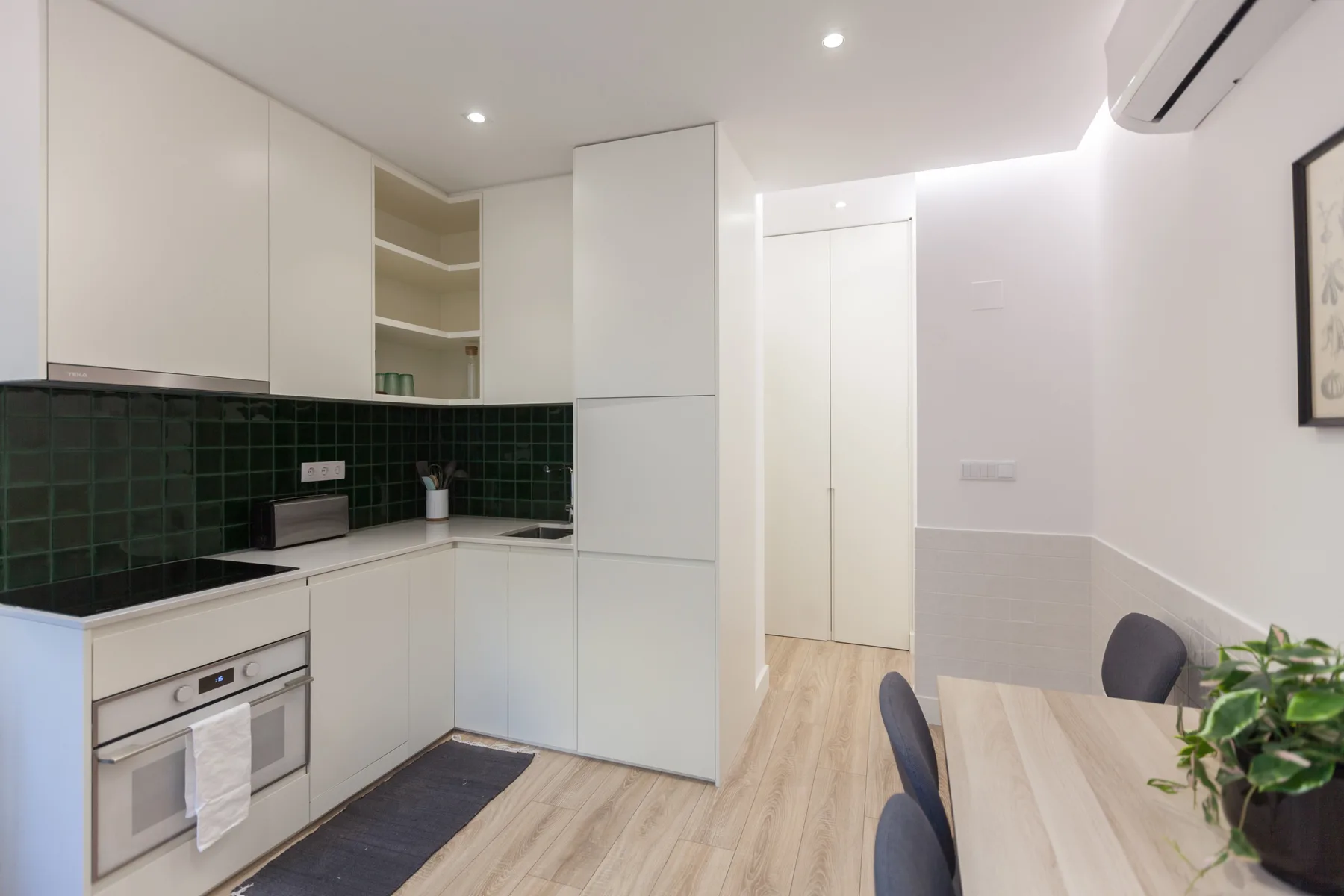A bright kitchen with white cabinets and a dining table.