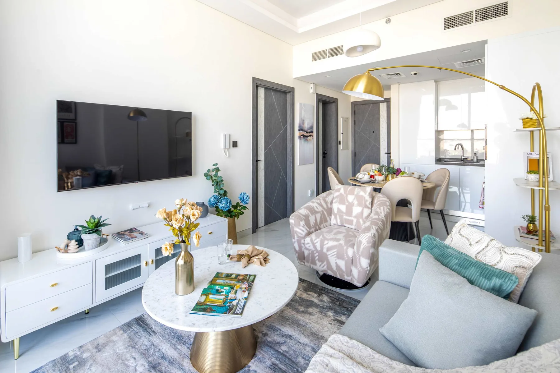 A bright living room with a seating area, coffee table, and dining space.