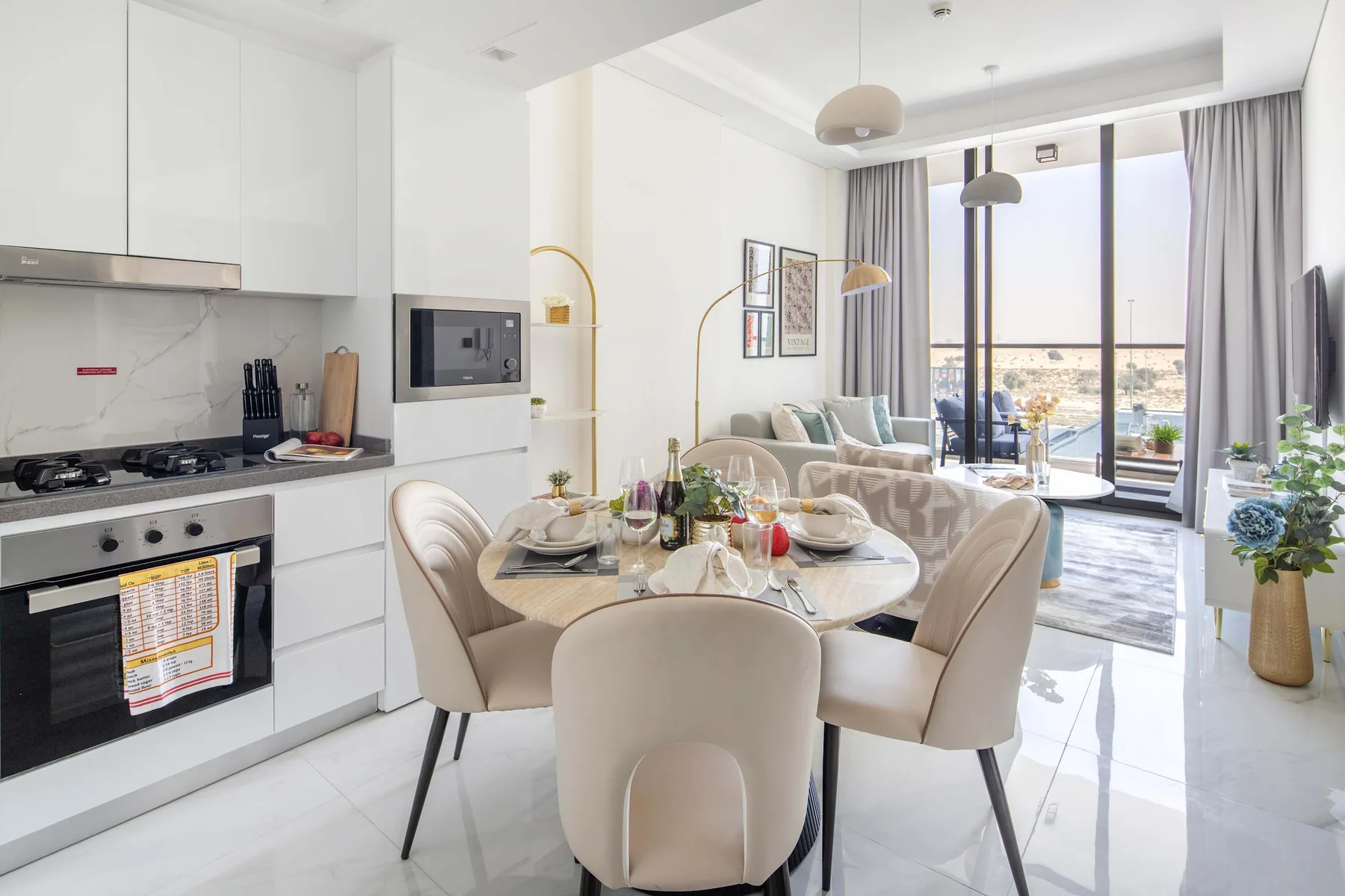 A bright open-plan kitchen and dining area with seating by the windows.