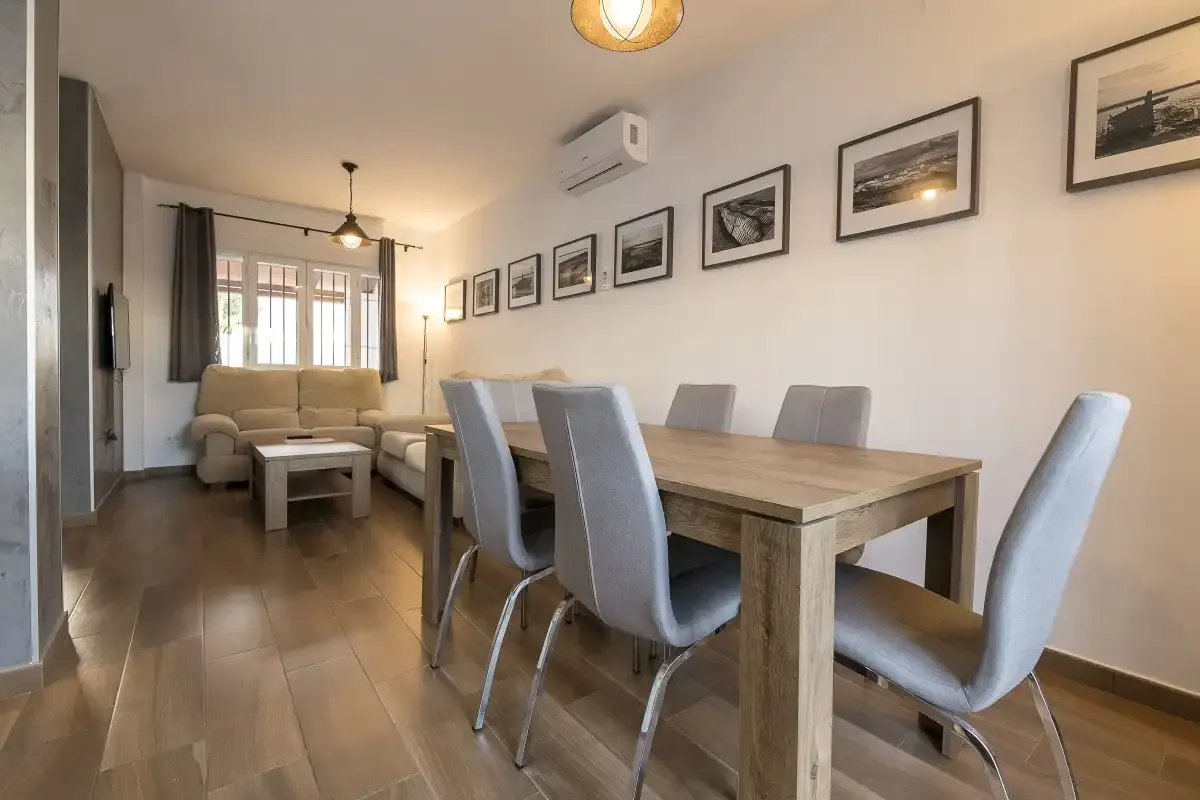 A dining and living area with a wooden table and seating.