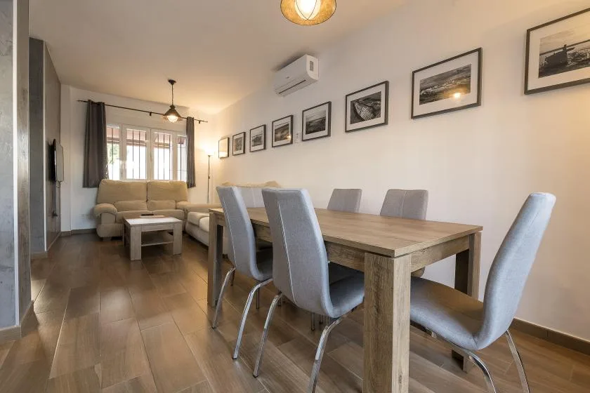 A dining area with a table and chairs opens onto a living room.