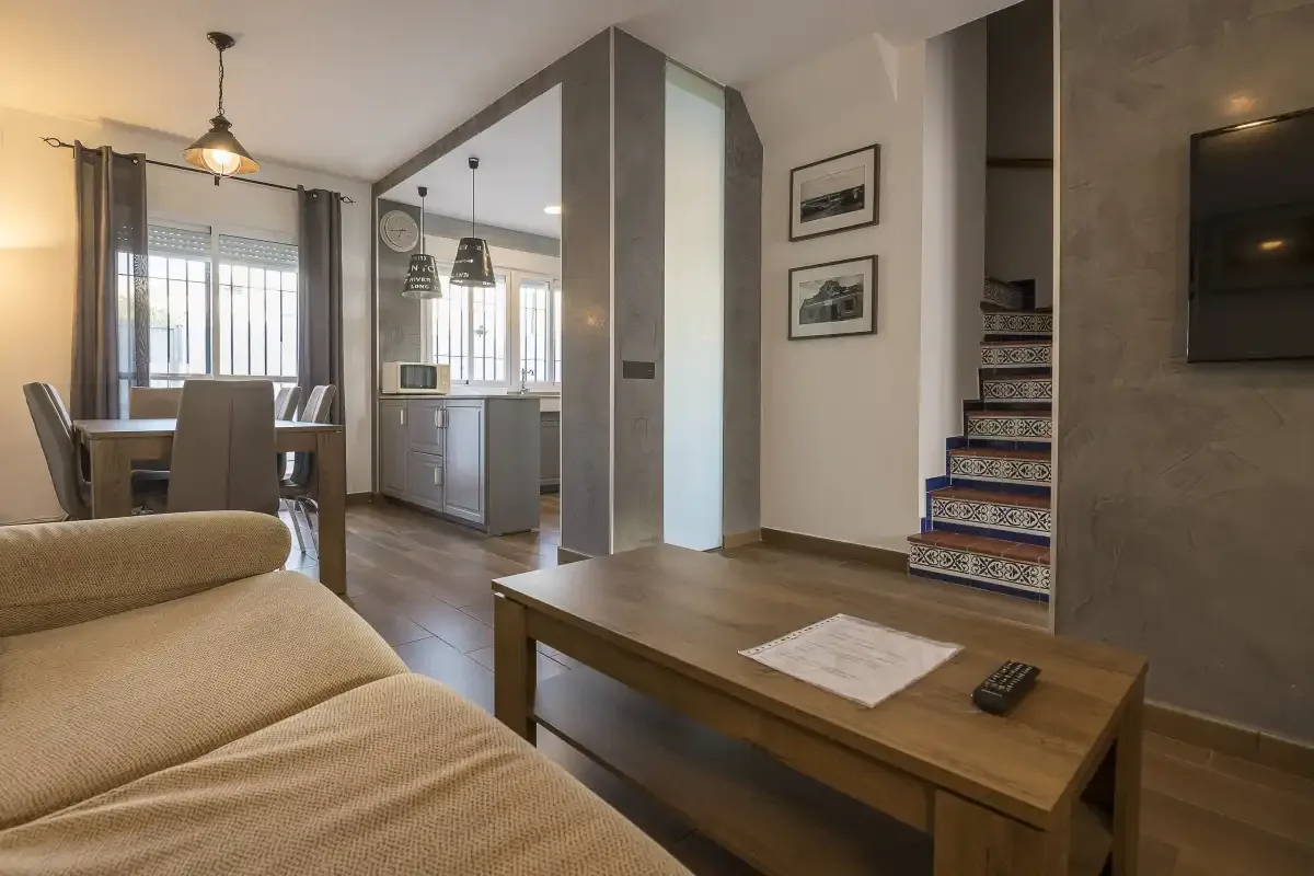 An open-plan living and dining area with a wooden coffee table and kitchen beyond.