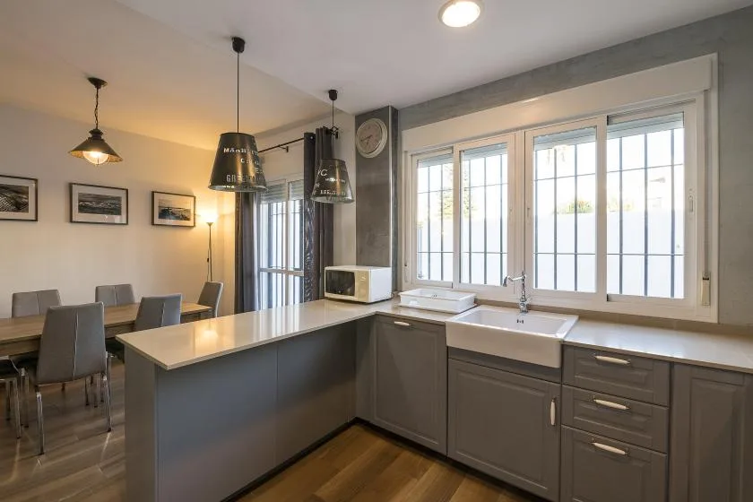 A bright kitchen with a central island and a dining table.