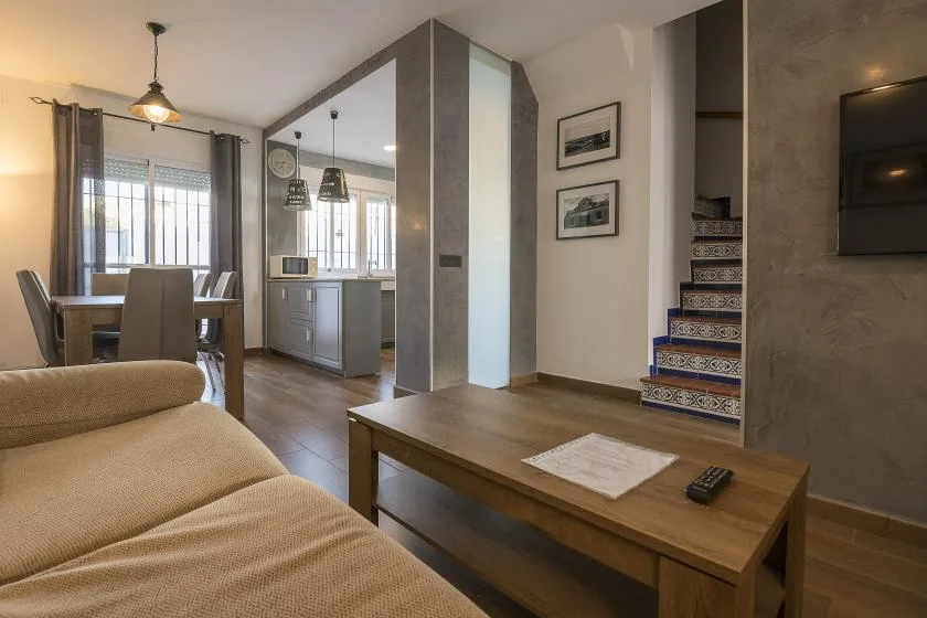 An open-plan living and dining area with a kitchen and staircase.