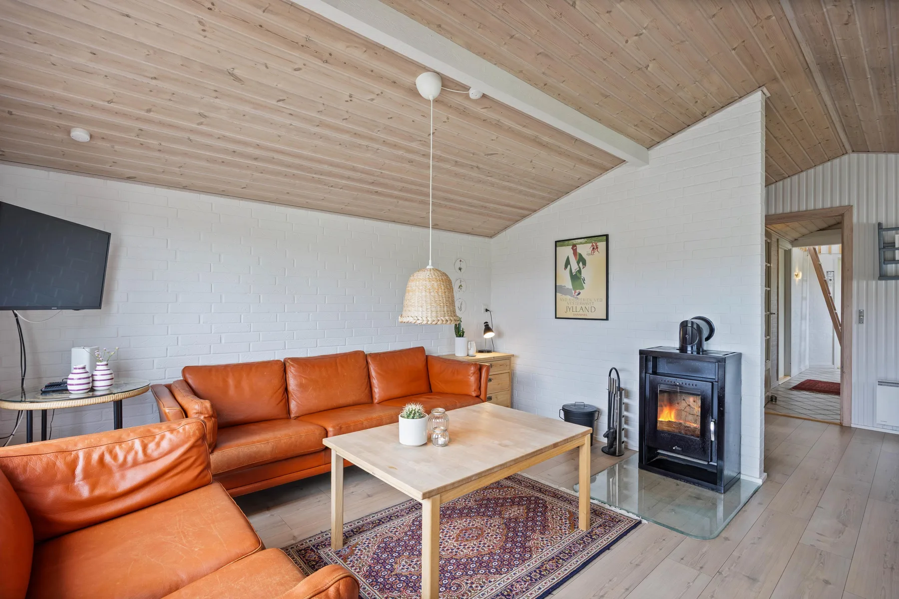 Living room with orange seating, a coffee table, and a fireplace.