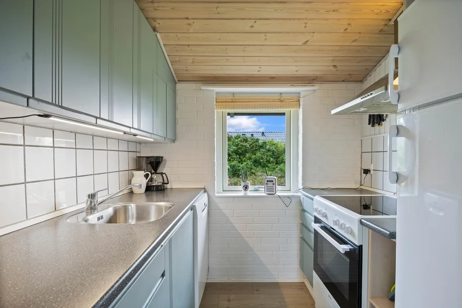 A narrow kitchen with counters on both sides and a window at the end.
