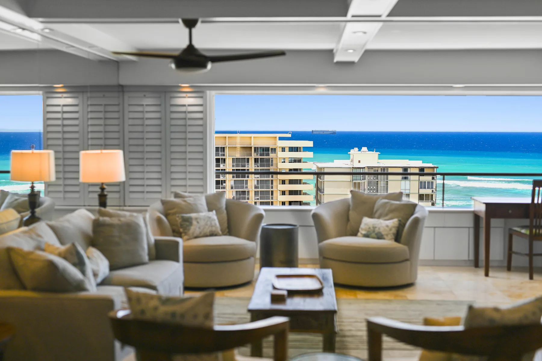 Una sala de estar con asientos y una mesa de centro frente a una amplia vista al mar.