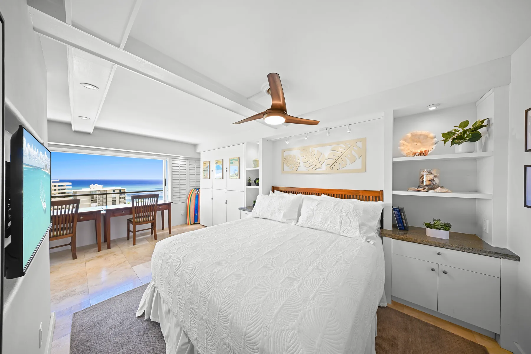 Un dormitorio luminoso con una cama grande, estantes empotrados y vistas al balcón.