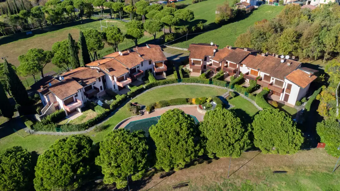 An aerial view shows several homes arranged around a curved garden path.