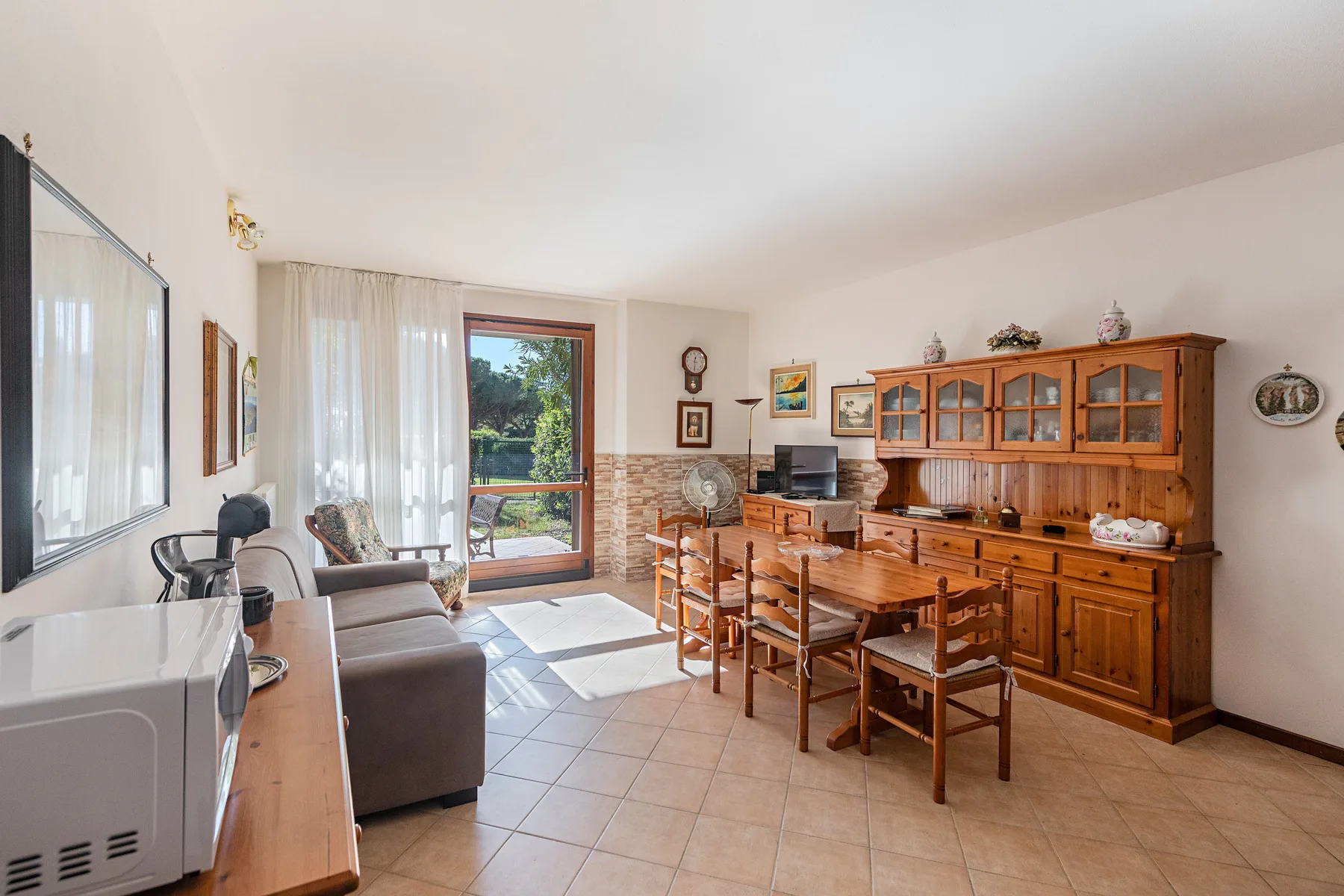 A living and dining room with a wooden table, chairs, and cabinet.
