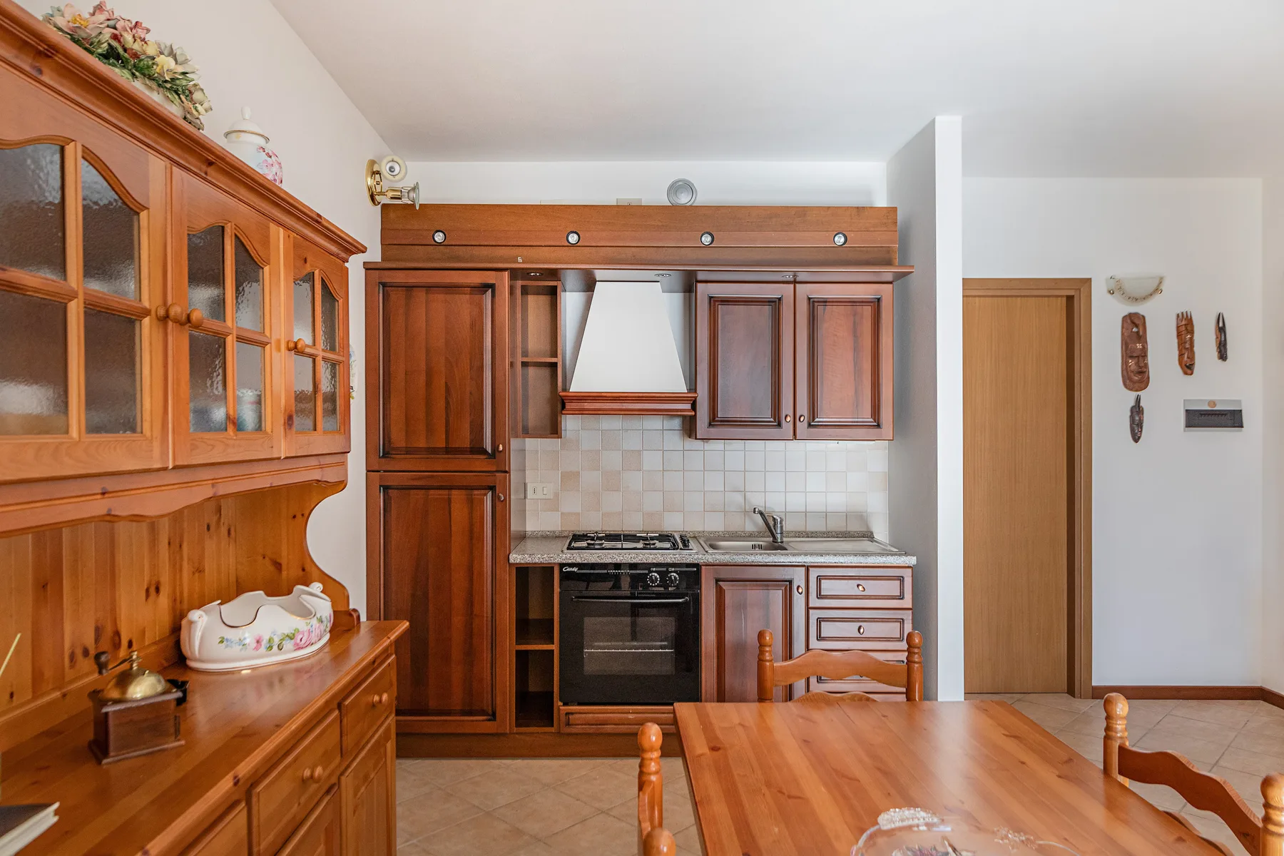 A wood-furnished kitchen and dining area with cabinetry, a stove, and a table.