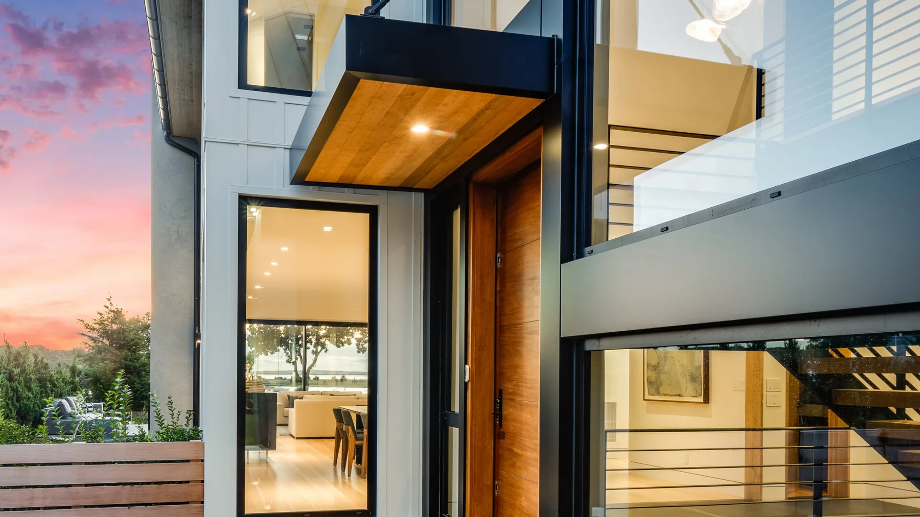 A modern house entrance with a wooden door and large glass windows.