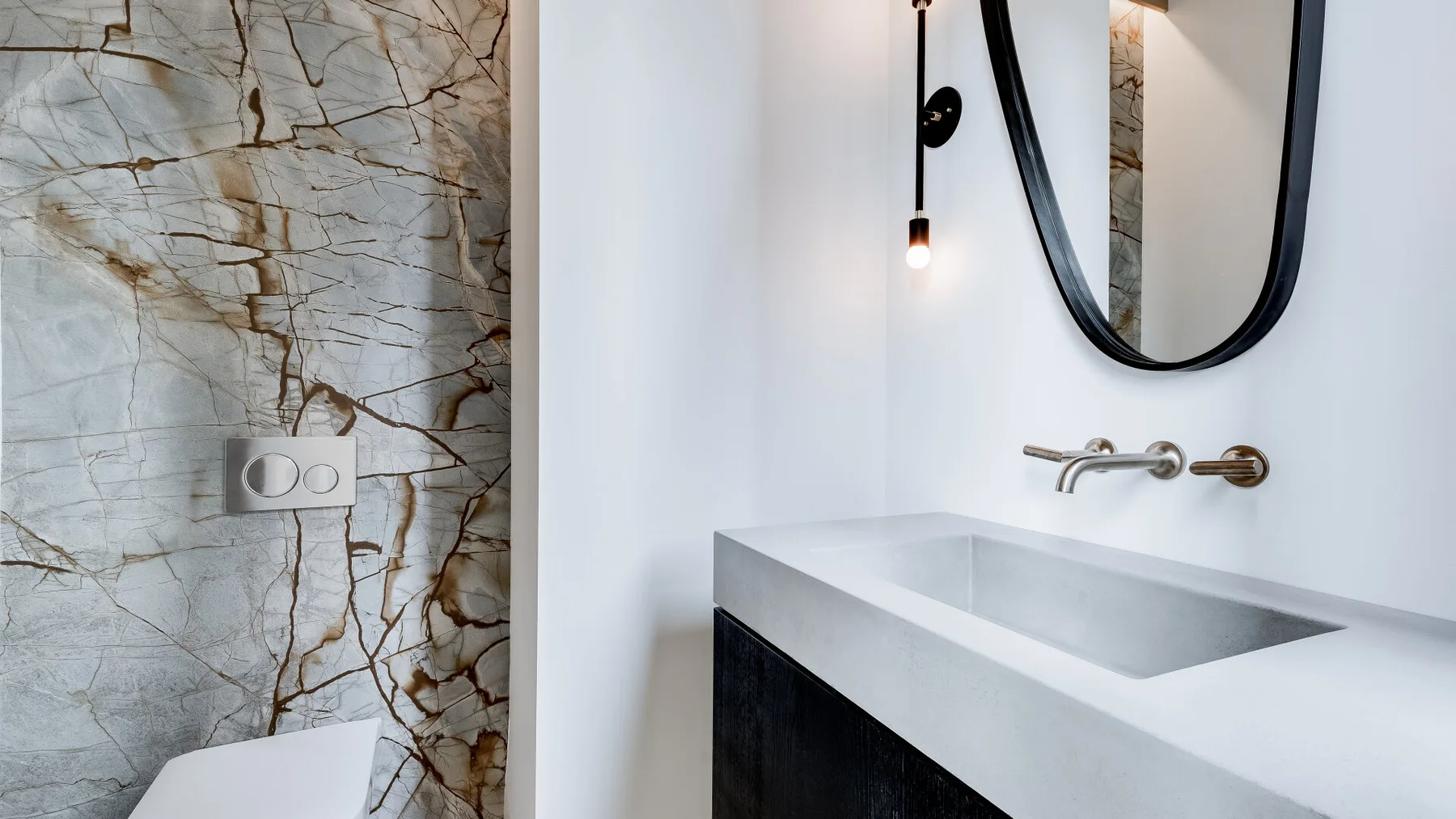 A modern bathroom vanity with a wide basin and wall-mounted mirror.