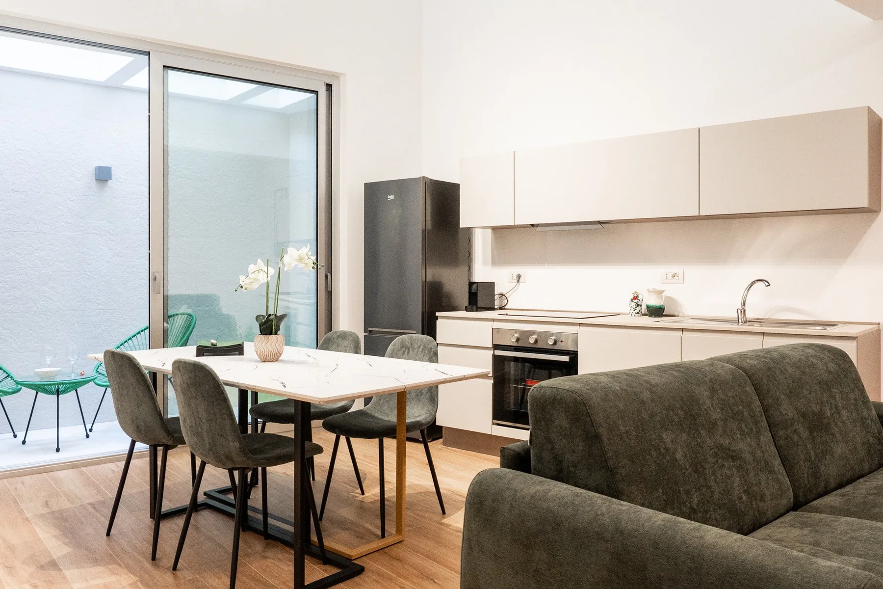 Una luminosa zona de comedor y cocina, con mesa y asientos junto a la encimera.