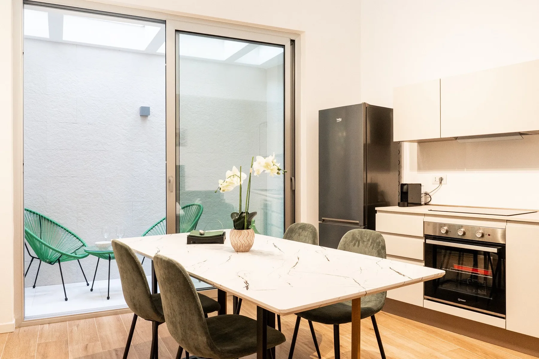 Un comedor con una mesa y sillas junto a una cocina compacta.