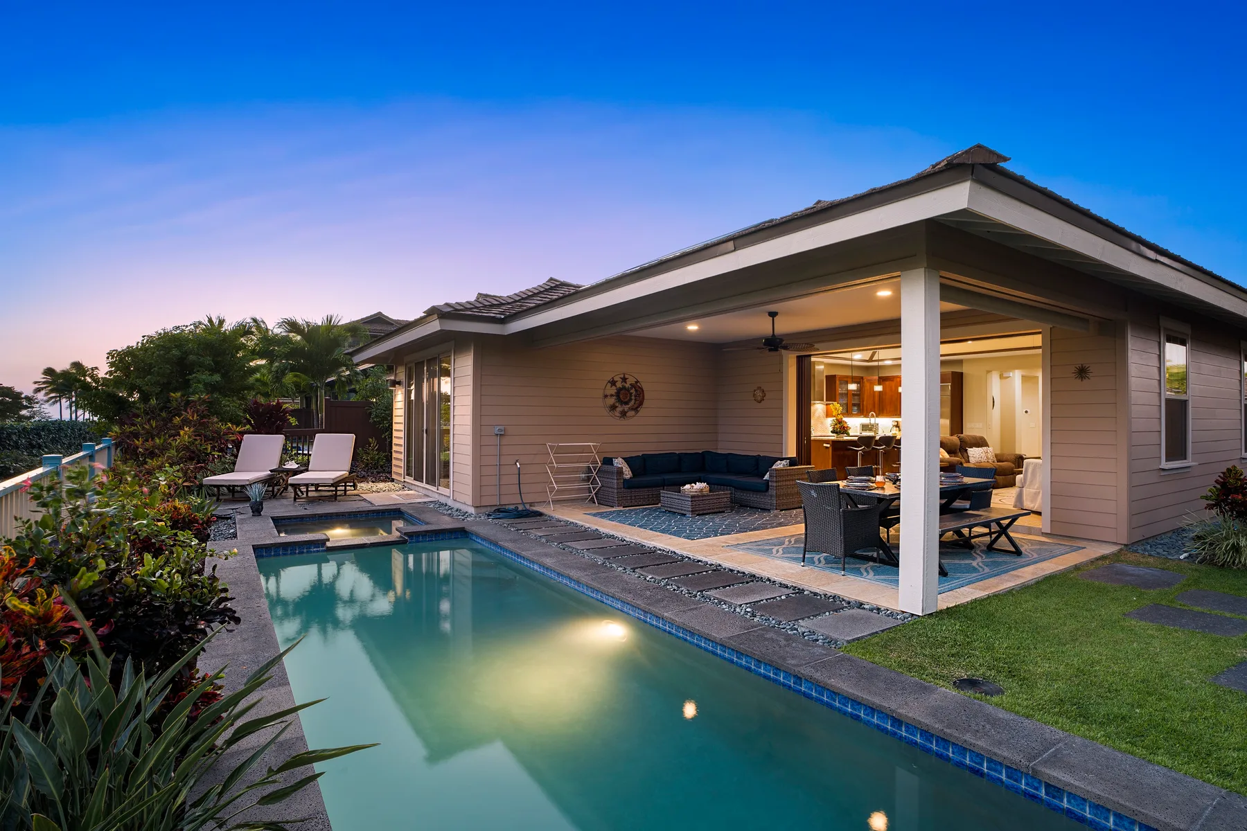 Una casa moderna da a un patio cubierto junto a una piscina.