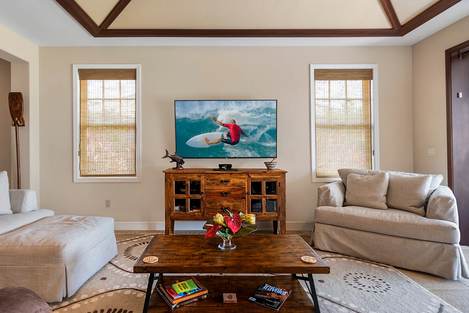 Una sala de estar con asientos alrededor de un televisor y una mesa de centro de madera.