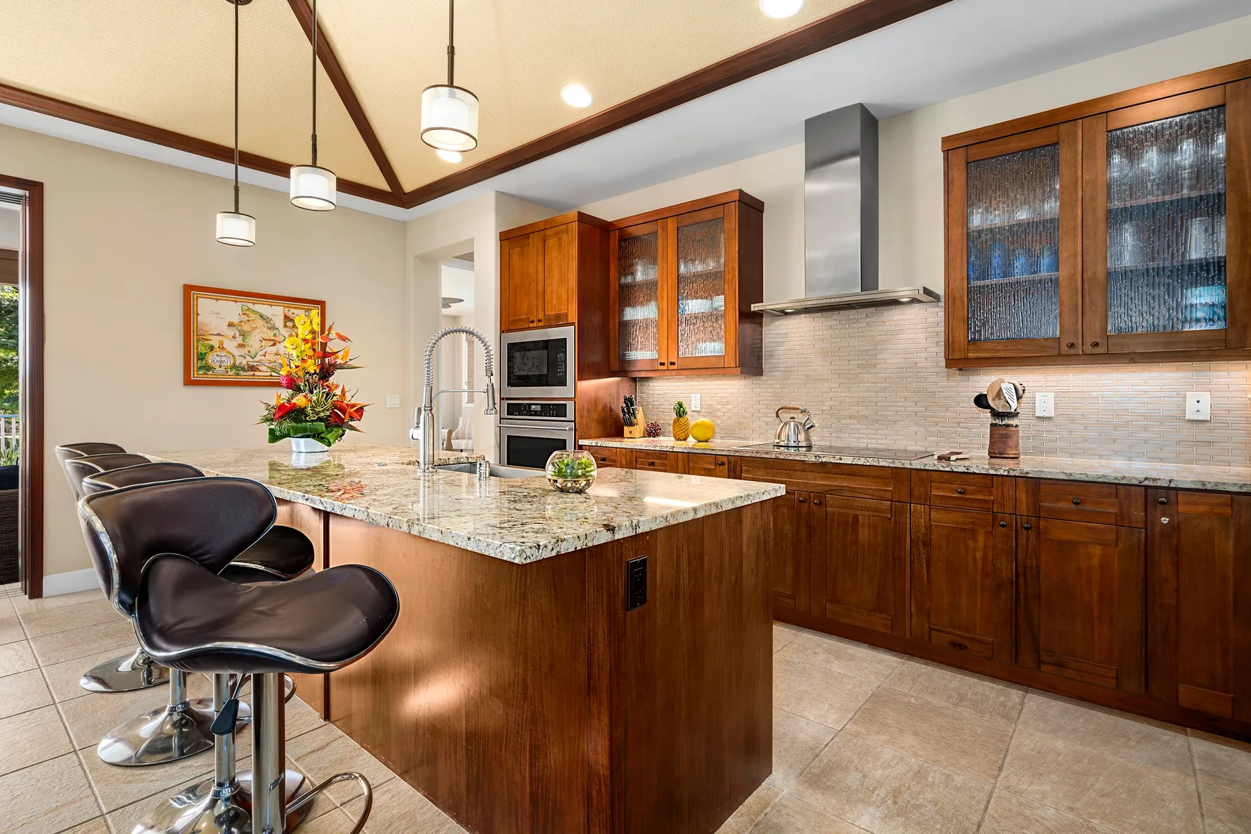 Una cocina con una isla grande, gabinetes de madera y taburetes.