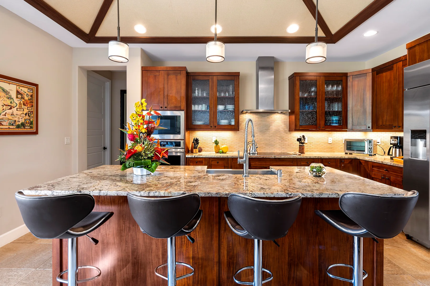 Una cocina amplia con una isla grande, asientos de barra y gabinetes de madera.