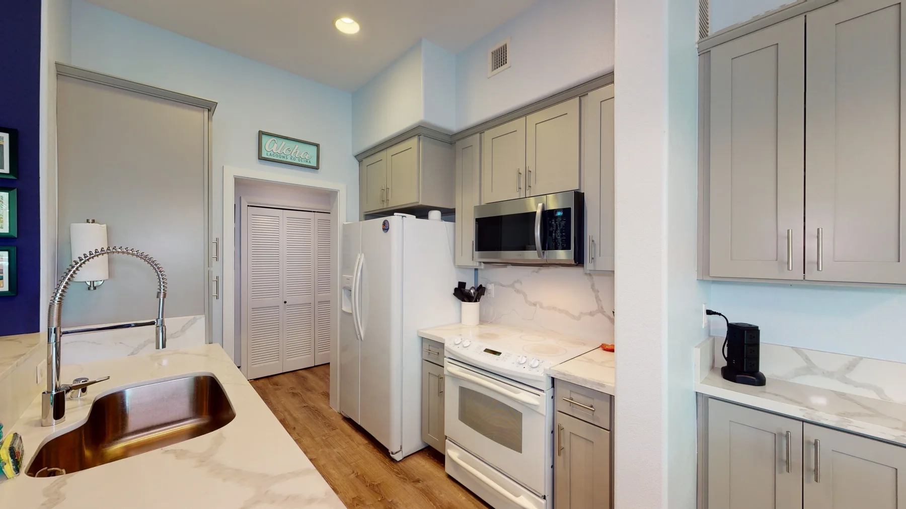 Una cocina luminosa con gabinetes claros, refrigerador y horno integrado.