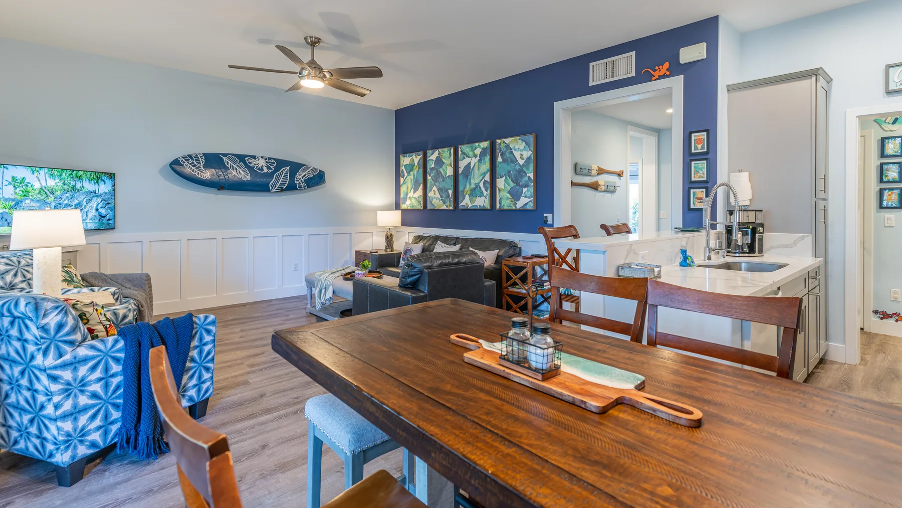 Una sala de estar y comedor con una mesa de madera, asientos y una barra de cocina.