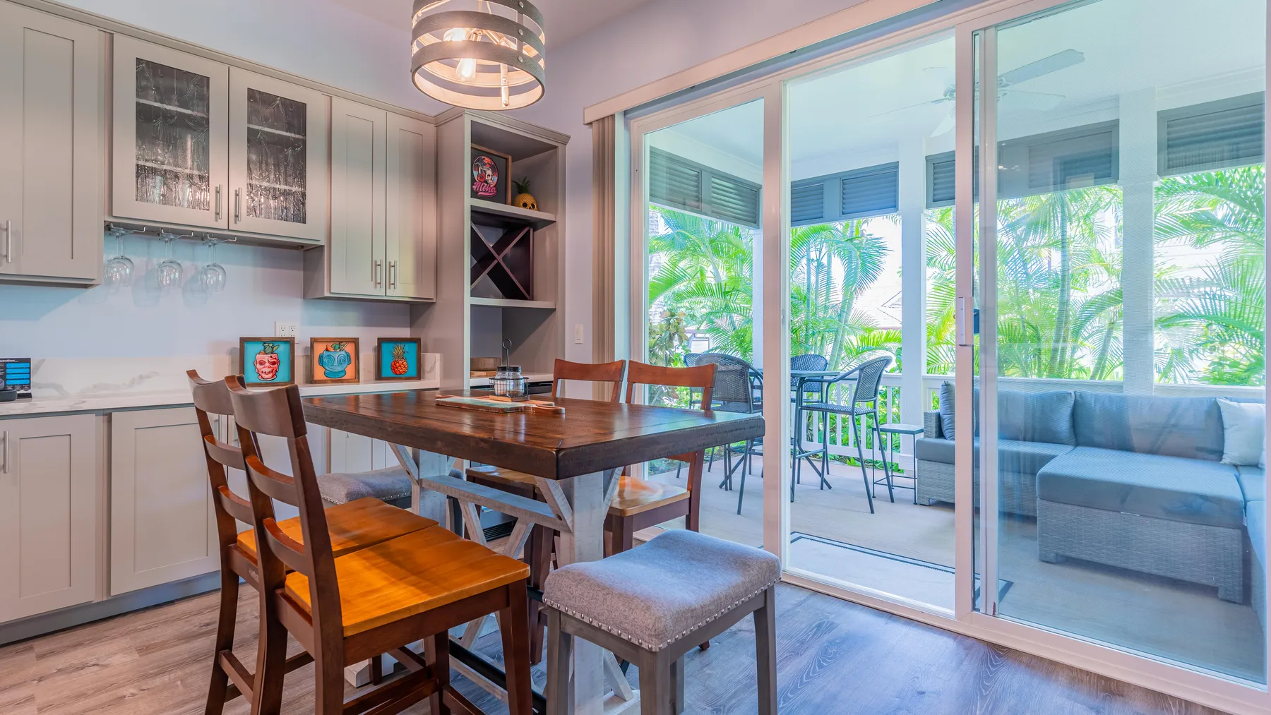 Un comedor con una mesa de madera y sillas junto a grandes puertas de vidrio.