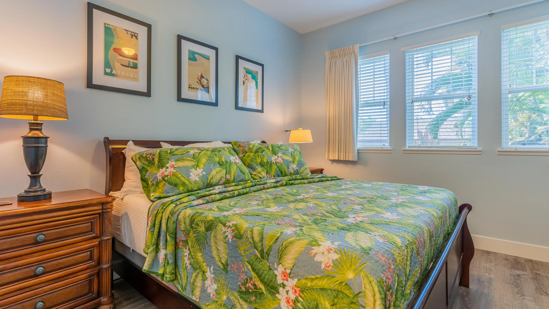 Un dormitorio con una cama grande cubierta con una colcha de estampado floral colorido.