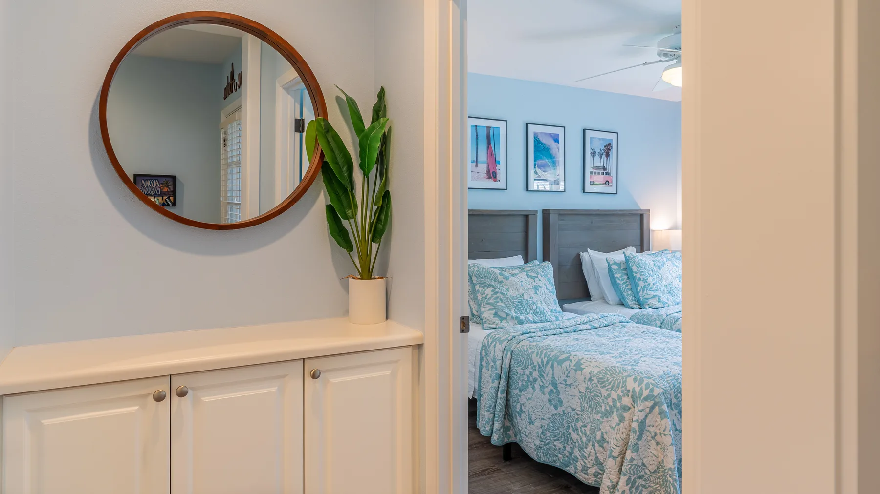 Un dormitorio con dos camas vestidas con ropa de cama azul estampada.
